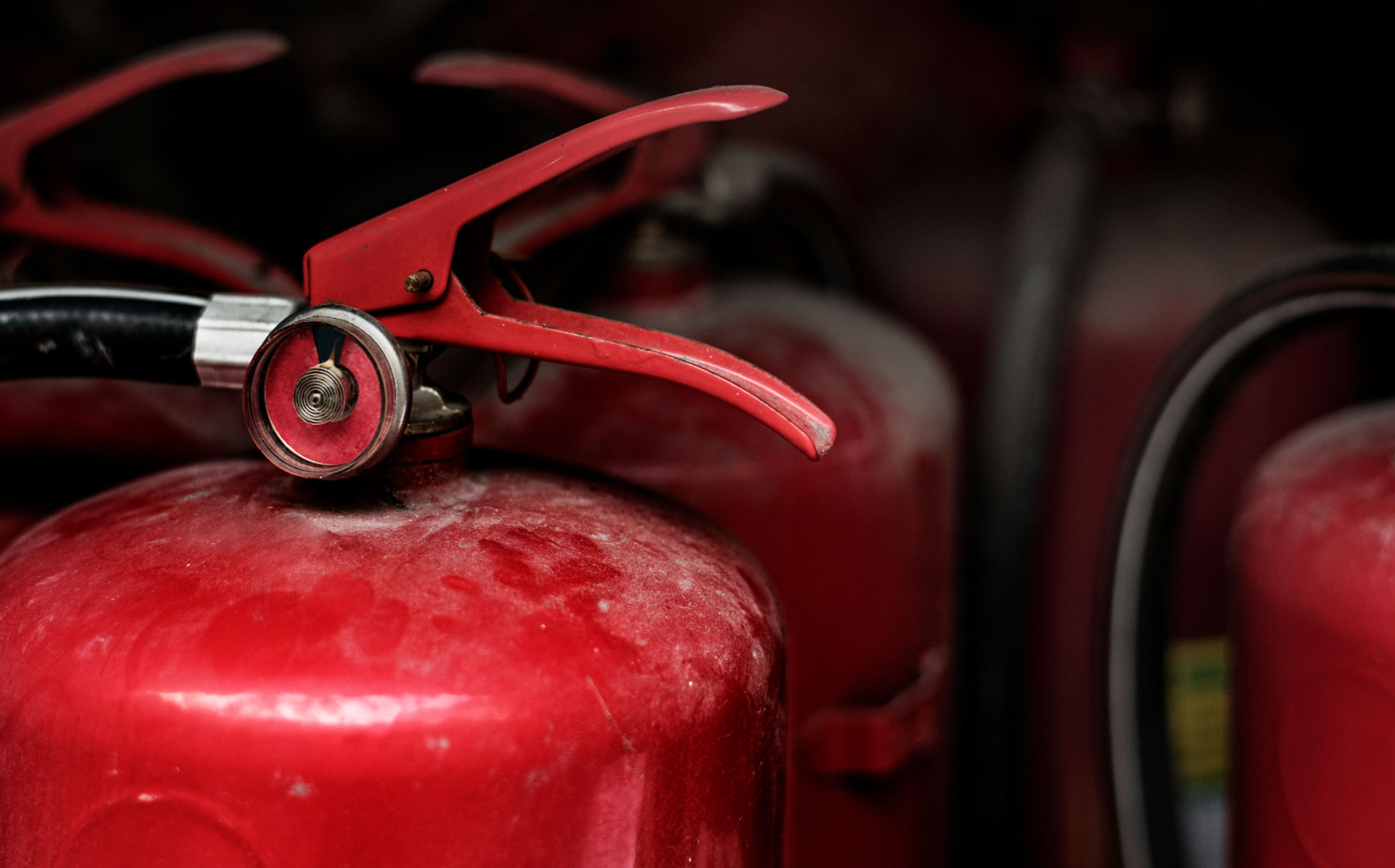 Foto von mehreren Feuerlöschern, einer ist groß im Vordergrund.